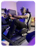 Student wearing sensors and driving a car simulator
